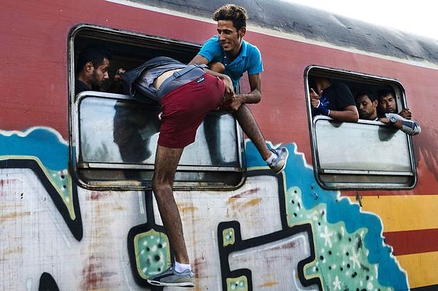 a-migrant-tries-to-get-onto-a-train-heading-to-the-border-with-serbia-at-the-train-station.jpg