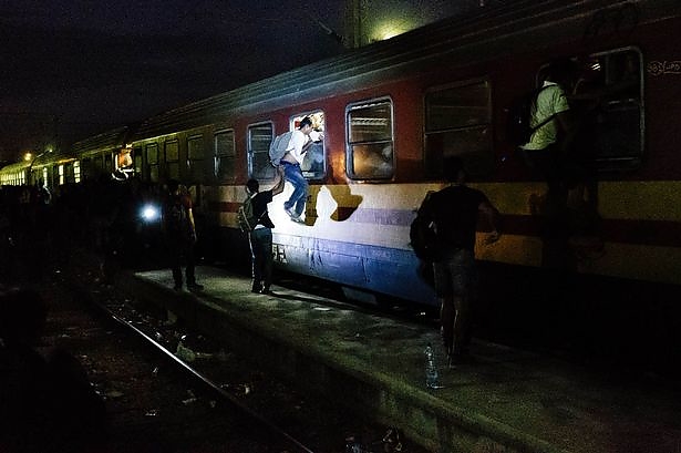 migrants-try-through-the-windows-to-climb-onto-a-train-heading-to-the-border.jpg